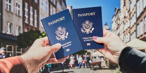 Two passports held up in a city street