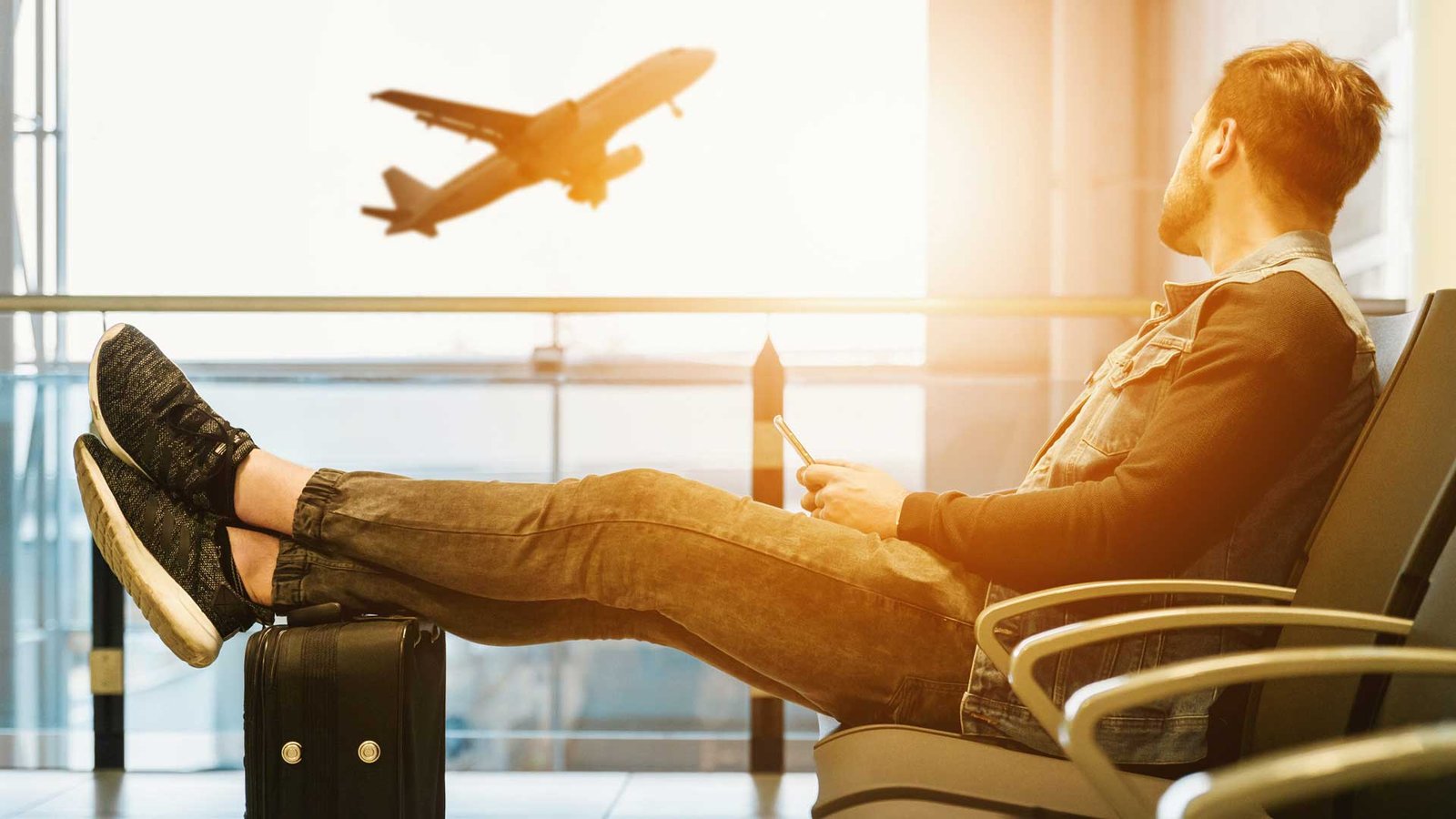 Student waiting at the airport as a plane takes off