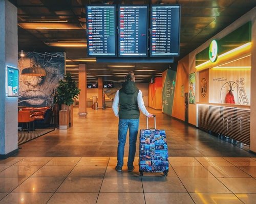 Student with a suitcase in an airport departure hall